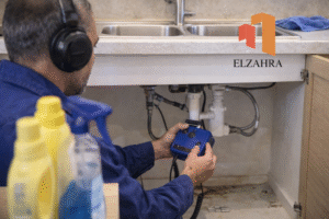 شركة كشف تسربات المياه بحي الخالدية – نجران يقوم فني مختص بفحص تسربات المياه أسفل حوض المطبخ باستخدام أجهزة حديثة بدقة عالية وبدون تكسير مع ظهور لوجو الزهراء