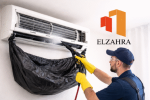 غسيل مكيفات بنجران – فني متخصص ينفذ تنظيف مكيف سبليت من الداخل باستخدام معدات حديثة مع إبراز شعار شركة الزهراء